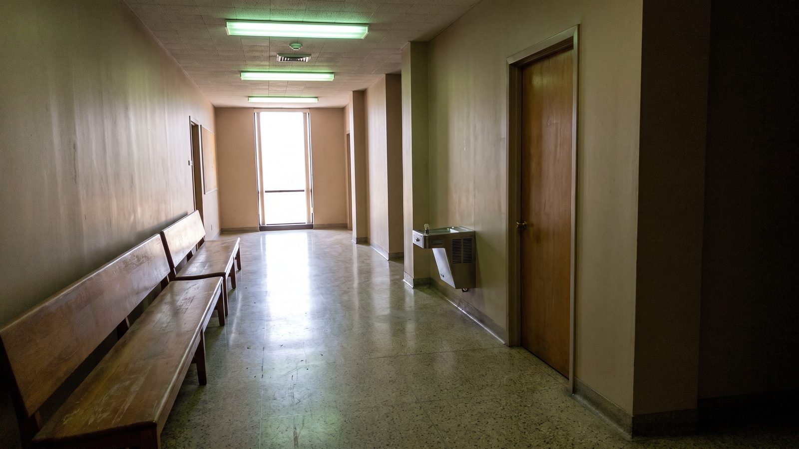 A corridor in a government building with wooden benches along one wall (illustrative photo, not the Durham County Courthouse).